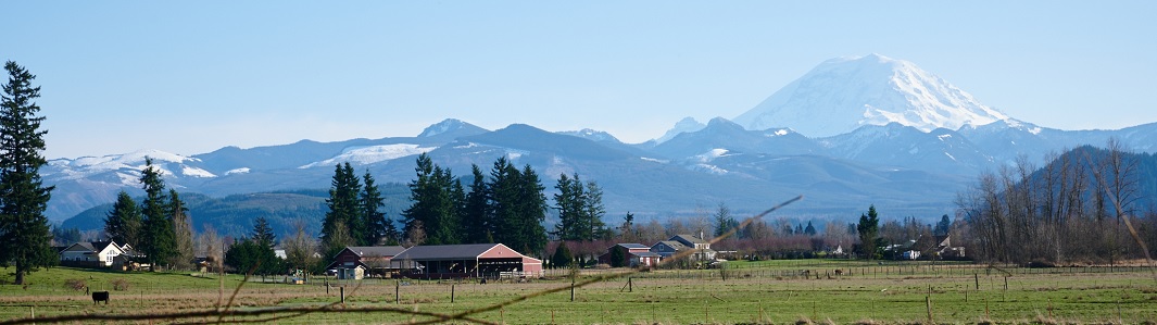 Farm scene with backdrop of mountains